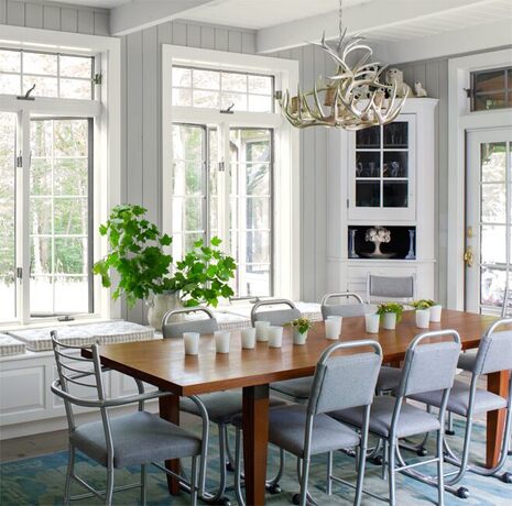 An airy dining room in grays and whites invites guests to the table.