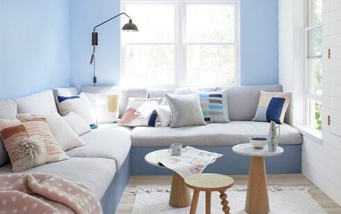 Blue & white living room with gray sectional & 3 end tables.