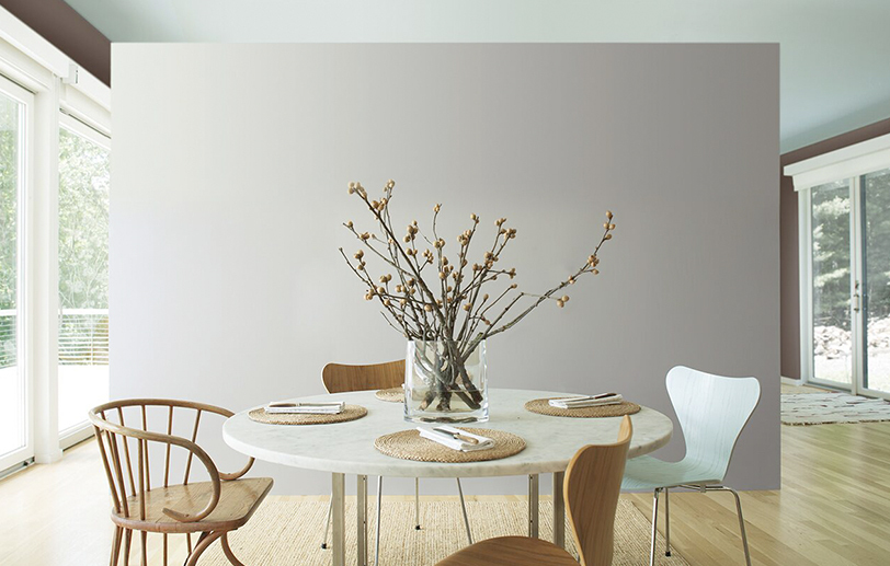 Amplia cocina con paredes en gris y techo color menta; Mesa circular con sillas de madera.