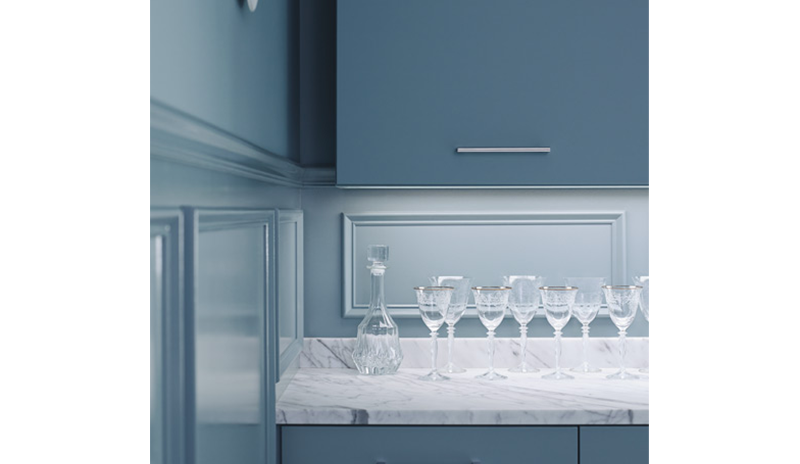 Monochromatic blue cabinets and blue walls are highlighted by a white marble countertop set with win
