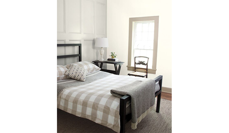 Relajante dormitorio con revestimiento de madera gris detrás de una cama negra. Relajante dormitorio con revestimiento de madera gris detrás de una cama negra.