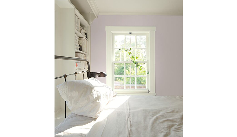 Dormitorio con paredes en rosa claro, estanterías empotradas en blanco y cama con sábanas blancas. Dormitorio con paredes en rosa claro, estanterías empotradas en blanco y cama con sábanas blancas.