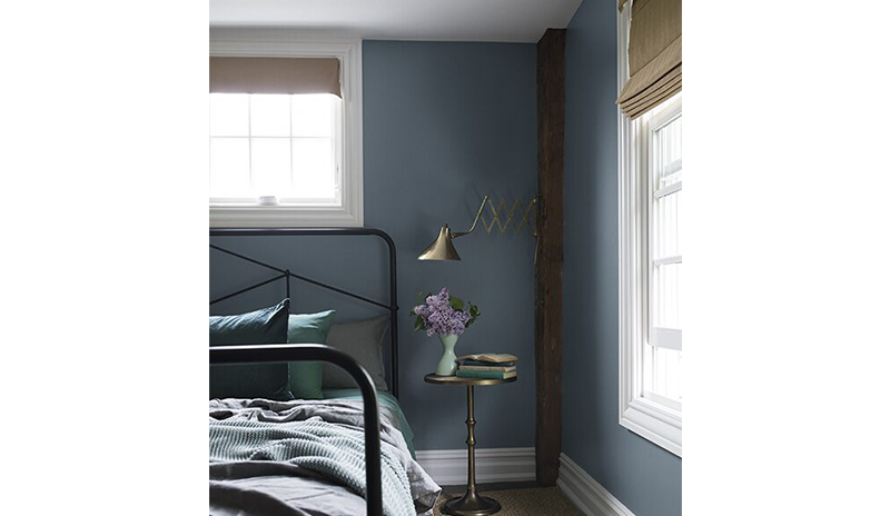 Un dormitorio azul pintado en Black Pepper 2130-40 con vigas de madera vistas y una cama de metal. Un dormitorio azul pintado en Black Pepper 2130-40 con vigas de madera vistas y una cama de metal.