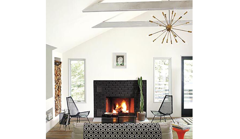 A modern white living room with black brick fireplace and hardwood floors.