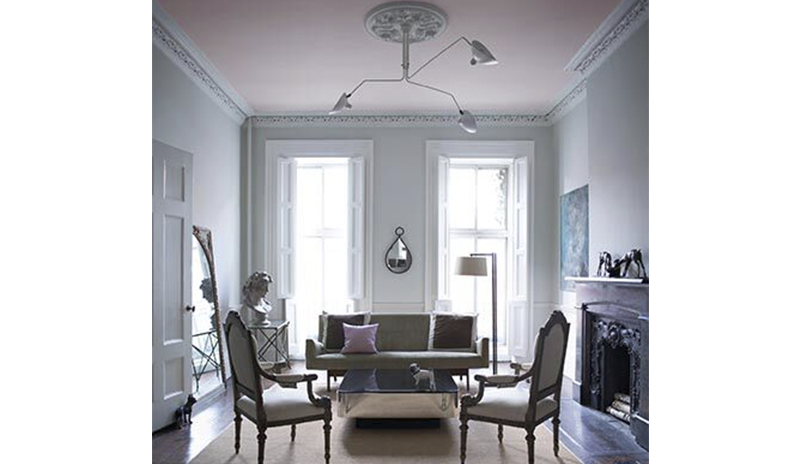 A classic gray living room with powder pink ceiling and floor to ceiling windows.