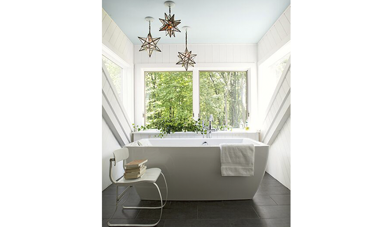 Bathroom with a soft blue ceiling and white modern bathtub.