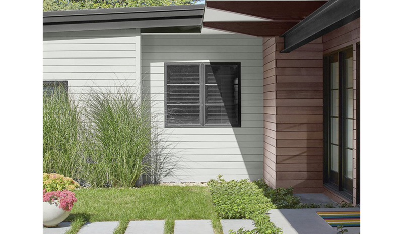 A light, gray-painted modern house with black trim and brown stain