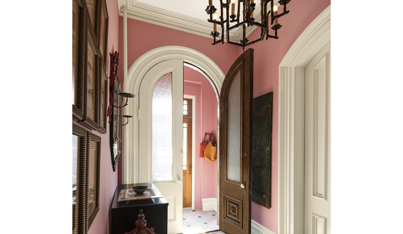 A traditional hallway and vestibule with pink-painted walls, white trim, doors, and ceiling A traditional hallway and vestibule with pink-painted walls, white trim, doors, and ceiling