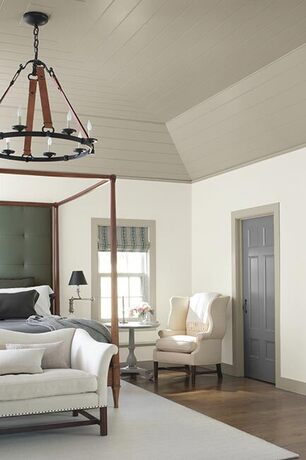 Gray and white bedroom with high ceiling accents and hardwood floors.