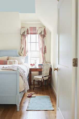 Cozy top floor bedroom with soft light blue ceiling and matching decor.