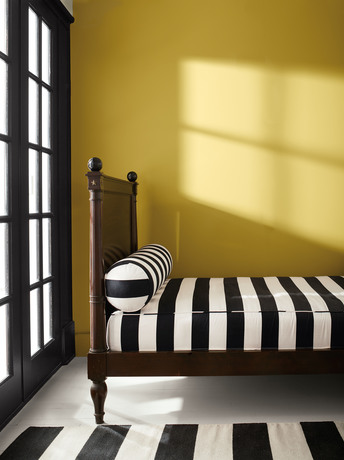 Savannah Green-painted bedroom with Onyx black-painted doors, wooden bed, and white floor.