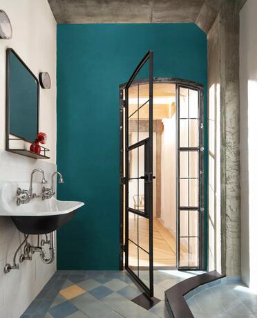 Pared decorativa pintada en color North Sea Green, baño Etiquette y puertas Onyx.