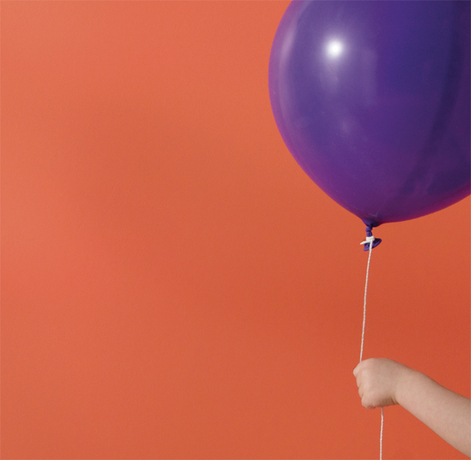 Una pared pintada de naranja enmarca un globo morado.