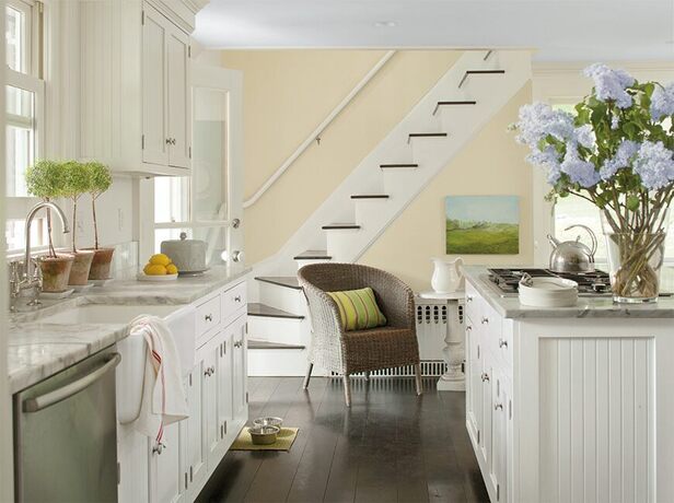 Open countryside kitchen with white cabinets and dark hardwood floors