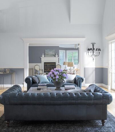 A serene living room in a combination of white and gray paint features two large leather couches.