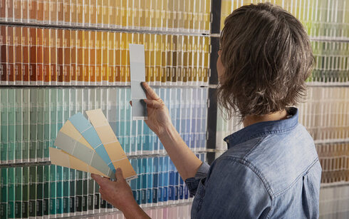 Mujer inspeccionando varias muestras de pintura
