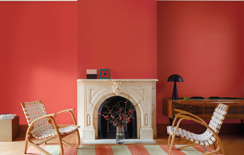 Living room with Raspberry Blush red-painted walls, white marble fireplace and relaxed seating.