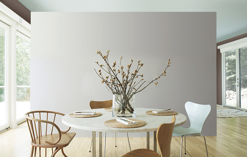 Airy kitchen with gray accent wall and mint ceiling;  circular table with wooden chairs.