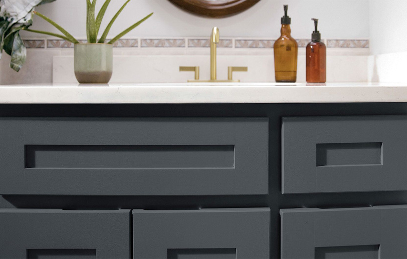 A close-up of a dark bathroom vanity cabinet with color  Van Deusen Blue HC-156 