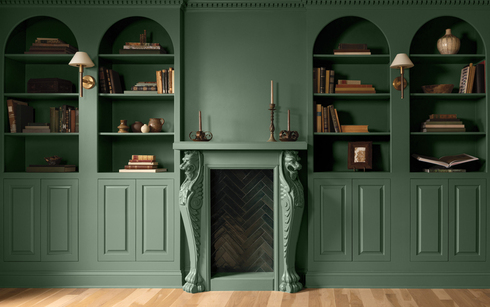 Una habitación pintada de verde con paneles en la parte inferior de las paredes